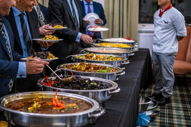 men-in-suits-choosing-food-from-table
